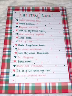 a christmas bucket list on top of a white bed with red and green plaid sheets