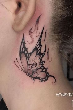 a woman's neck with a butterfly tattoo on the back of her neck and behind her ear