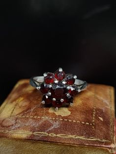 Here we have a beautiful vintage ring featuring a sparkling cluster of natural garnet gemstones set in sterling silver UK size - N US size - 6.75  Message me any questions  ITEM - S1858 Vintage Flower Ring Stamped 925 For Anniversary, Heirloom Cluster Ring Gift, Collectible Cluster Gemstone Rings, Vintage Flower Ring With Prong Setting For Anniversary, Vintage Multi-stone Cluster Ring, Vintage Hallmarked Flower Ring For Formal Occasions, Vintage Sterling Silver Ruby Ring For Formal Occasion, Vintage Multi-stone Cluster Ring For Anniversary, Vintage Ruby Cluster Ring For Formal Occasions