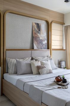 a bedroom with a large bed and paintings on the wall next to window sill