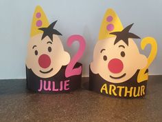 two paper hats with clown faces and the words jubilee and arthrur written on them