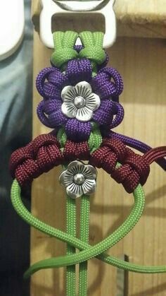 three flowers are attached to the handle of a sewing machine with green and purple cords