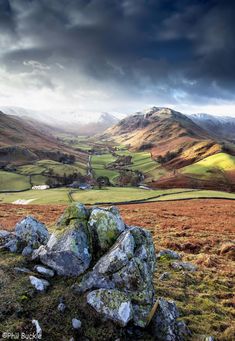 a rocky outcropping on the side of a mountain under a cloudy sky