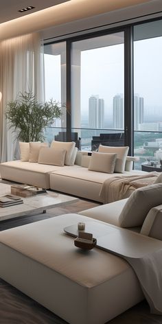 a living room filled with lots of furniture and large windows overlooking the cityscape