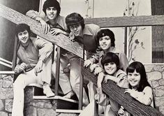 an old black and white photo of some people on the stairs with their arms around each other