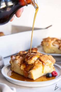 someone is pouring syrup on a piece of bread