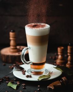 a cappuccino is being sprinkled with cinnamon and sugar on a saucer