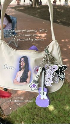 a white purse with an image of a woman's face is hanging from the handle