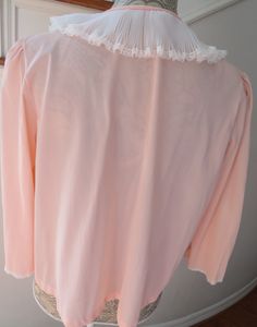 "Feel like a glamorous movie star from a bygone era in this lovely pink bed jacket. Beautifully crafted, this bed jacket is made of 100% Nylon and features a wide white ruffled nylon Peter Pan collar trimmed with white floral lace. The jacket closes with a snap at the collar. The wide bell sleeves have dainty nylon at the hems. This is a lovely vintage bed jacket that will certainly made you feel quite glamorous!! Maker: Miss Elaine Fabric: 100% Nylon Size: Medium Measurements: Shoulder to shoul Pink Bed, Bed Jacket, Womens Nightgowns, Pyjamas Womens, Vintage Bed, Women's Nightgowns, Bygone Era, Pink Bedding, Vintage Lingerie