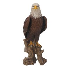 an eagle statue sitting on top of a tree branch