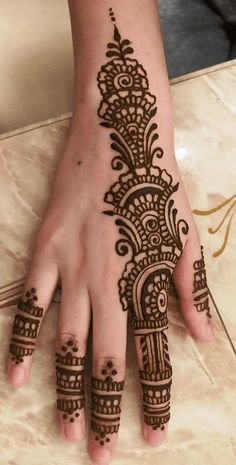 a woman's hand with henna tattoos on it