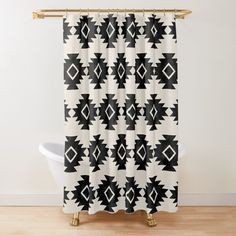 a black and white shower curtain with an abstract design on the front, in a bathroom