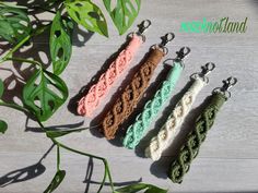 three crocheted key chains sitting on top of a wooden table next to a plant