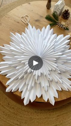 a white paper flower sitting on top of a wooden table