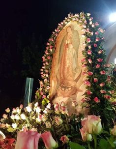 the statue is surrounded by flowers and greenery