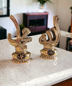 two golden decorative objects sitting on top of a counter