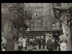 an old black and white photo of people walking down the street