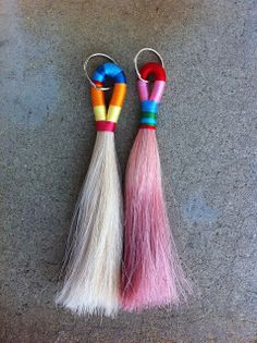 two small colorful tassels are laying on the ground