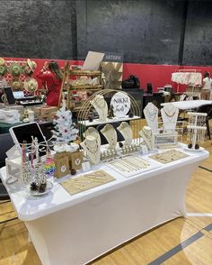 a table covered with lots of gold and white items at a trade show or sale