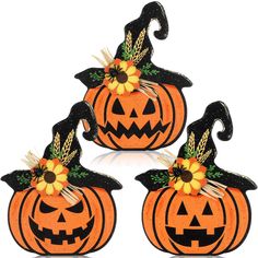 three pumpkins decorated with sunflower and witch hats