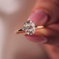 a close up of a person holding a ring with a diamond in it's center