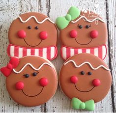 four decorated gingerbread cookies sitting on top of a wooden table