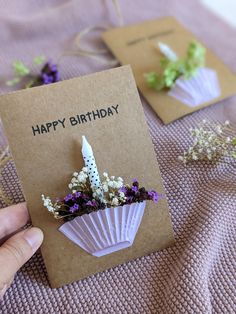 someone is holding a birthday card with flowers in it