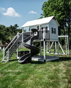 a play structure with a slide in the grass