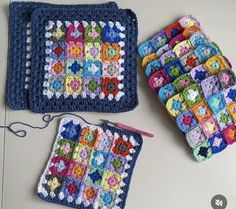 two crocheted squares are sitting next to each other on a table, one is blue and the other is multicolored