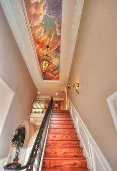 a staircase leading up to a painting on the ceiling