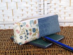 a pencil case sitting on top of a wicker table next to a notebook and pen