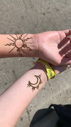 two people with tattoos on their arms holding hands