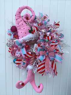 a pink umbrella is hanging on the wall with christmas decorations around it and ribbons attached to it