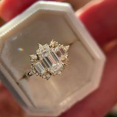 a person holding an engagement ring in their hand with the diamond setting on it's side