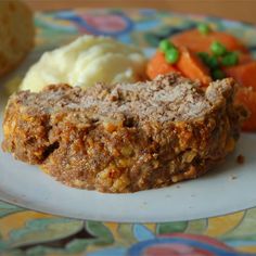 a close up of a plate of food with carrots and mashed potatoes on it