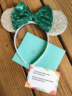 there is a card with a green bow on it and a mouse ears headband