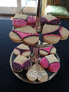 some cookies are on a plate with pink and black decorations