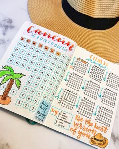 an open planner with the month and date on it, next to a straw hat