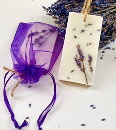 two soap bars sitting next to each other on top of a white table with purple flowers