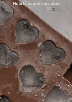 heart shaped ice cubes sitting on top of a table covered in chocolate frosting