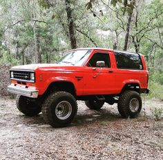 a red pick up truck parked in the woods