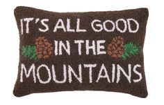 a brown pillow that says it's all good in the mountains with pine cones