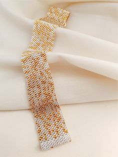 An elegant mix of 24k gold and silver lined glass beads that are randomly hand sewn that shimmers mesmerisingly. No two piece will ever be the seem, making your piece uniquely yours. Reminiscent of the sands of Gobi, this cuff is amazingly soft and light weight. Gobi is a slip on that adjusts to your size perfectly - whether you want it snug or slightly loose, just tug and pull gently. Gobi is another signature JeannieRichard piece that will find you articulating your gestures more with a touch Elegant Yellow Beaded Bracelets With Gold Beads, Elegant Yellow Beaded Bracelet With Gold Beads, Gold Beaded Bangle Cuff Bracelet, Elegant Yellow Beaded Bracelets For Jewelry Making, Elegant Yellow Polished Beaded Bracelets, Silver Beaded Bangle Bracelets With Gold Beads, Gold Beaded Cuff Bracelet With Round Beads, Gold Beaded Bracelets With Polished Beads For Party, Gold Beaded Bracelet With Polished Beads For Parties