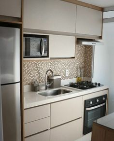 a small kitchen with white cabinets and stainless steel appliances, including a stove top oven