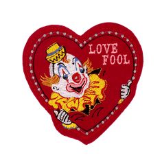 a heart shaped patch with an image of a clown in the center and words love fool on it