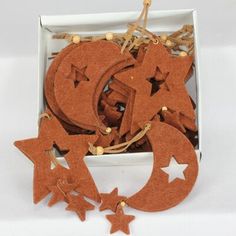 wooden stars and moon cutouts in a box on a white surface with string