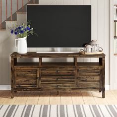 an entertainment center with drawers and a chalkboard on the wall in front of it