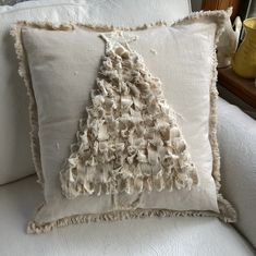 a white couch with a decorative pillow on it