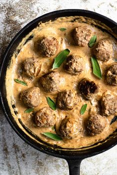 a skillet filled with meatballs covered in gravy