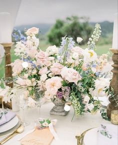 the table is set with white and pink flowers